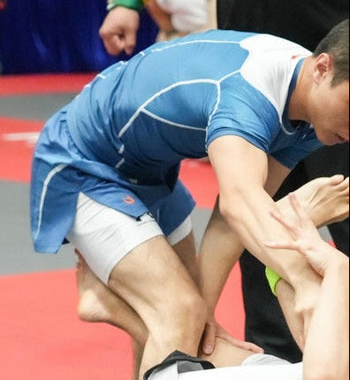 Tesshin Athlete passing guard in a competition wearing Coral Blue Fight Set