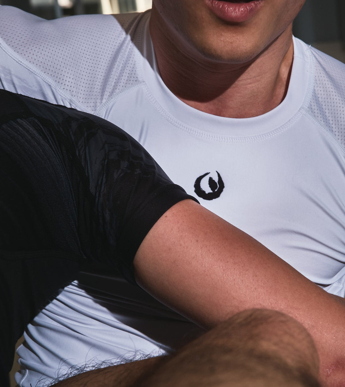 Athlete wearing Tesshin white rashguard during no-gi training