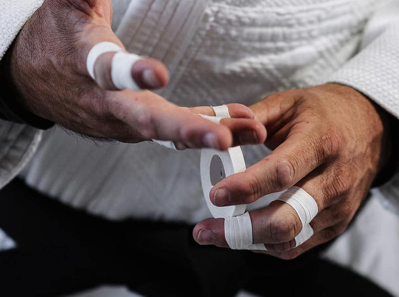 Athlete applying white finger tape